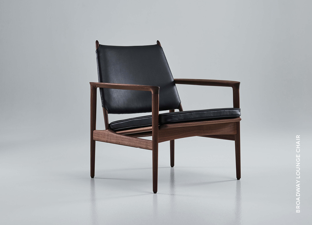 Eikund Broadway lounge chair ioled walnut and black leather upholstery in white background